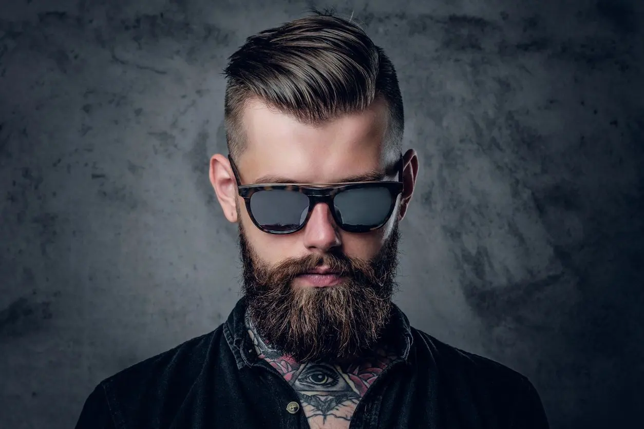 A man with a beard and sunglasses on.